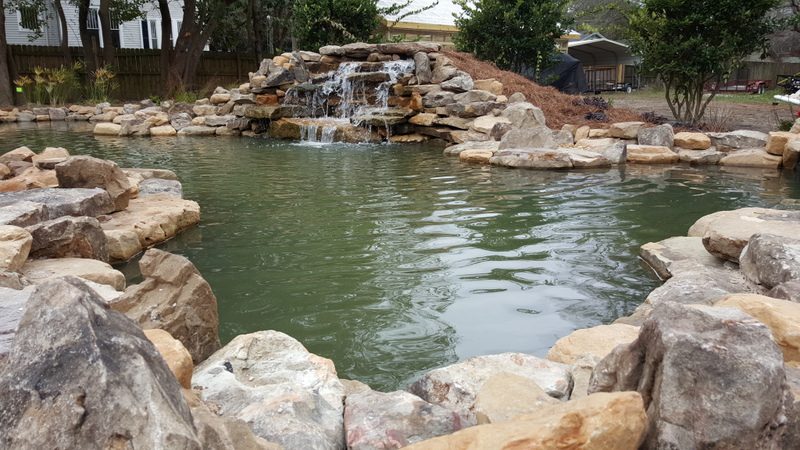 A pond with rocks and water features in it