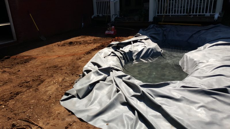 A pool that has been tarped and is in the ground.