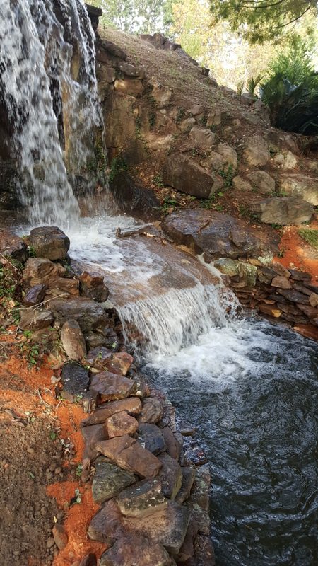 A waterfall with rocks and water running down it.
