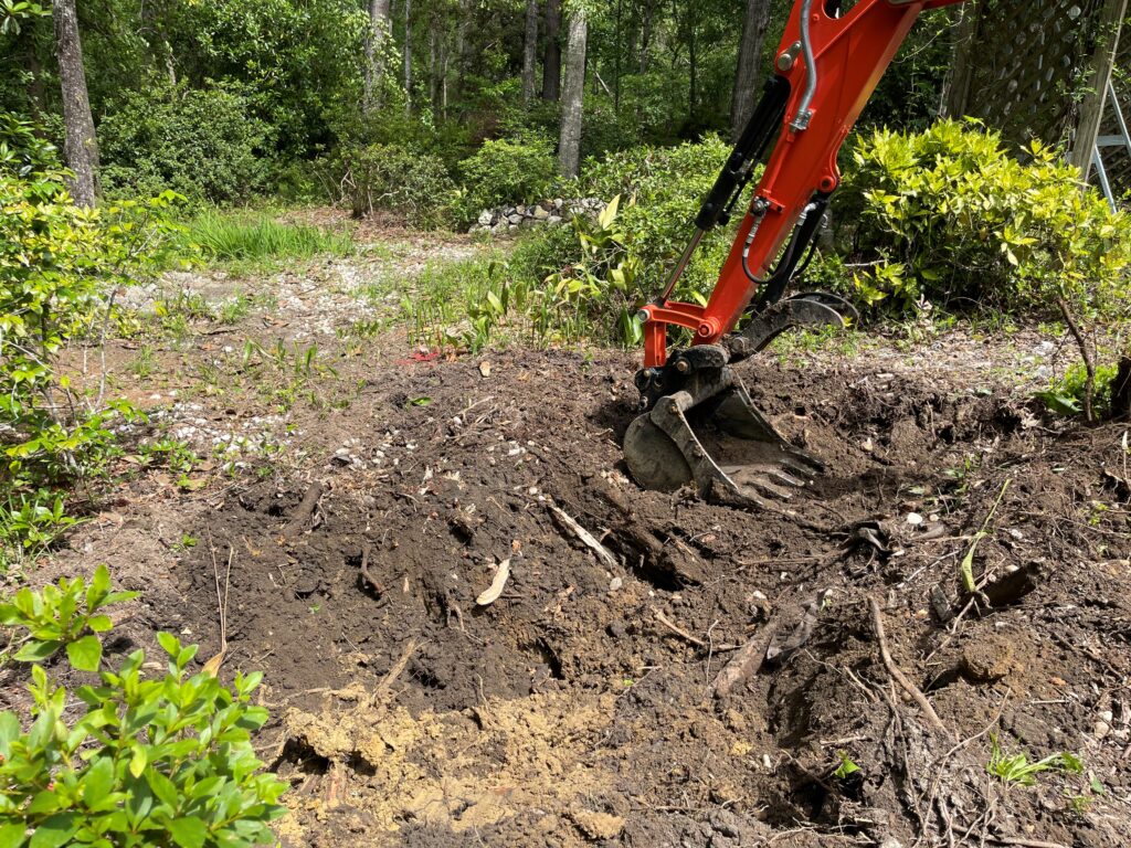 A red and black tractor is digging in the ground