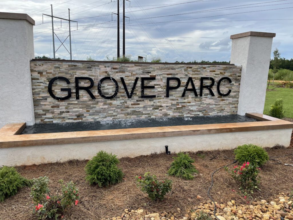 A sign that says grove parc in front of some bushes
