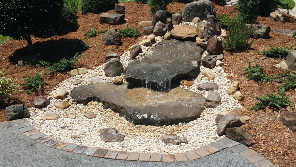 A small waterfall in the middle of a garden.