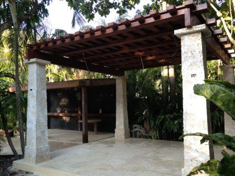 A patio with an open roof and stone pillars.