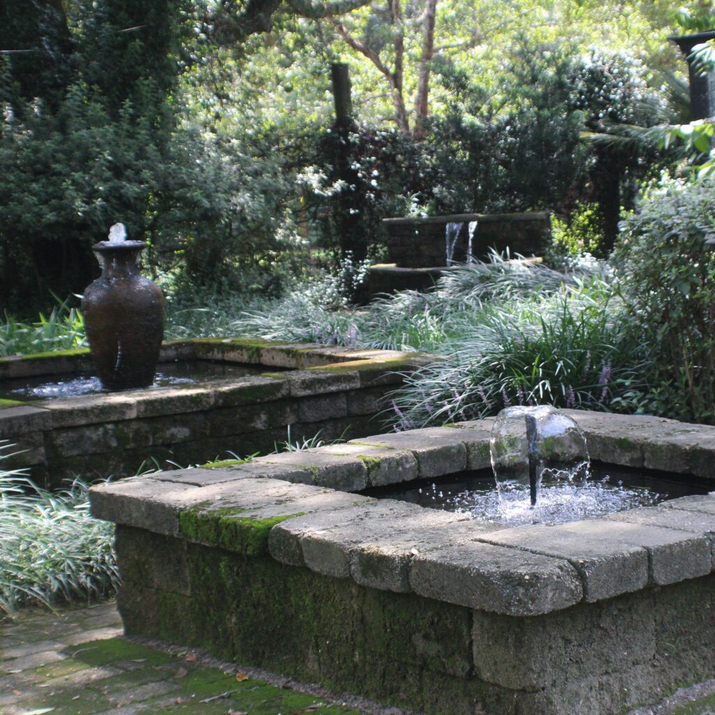 A fountain in the middle of some bushes