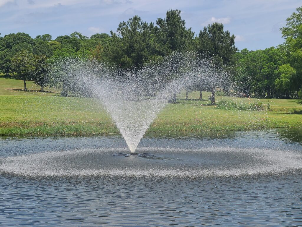 A fountain that is in the middle of some water.