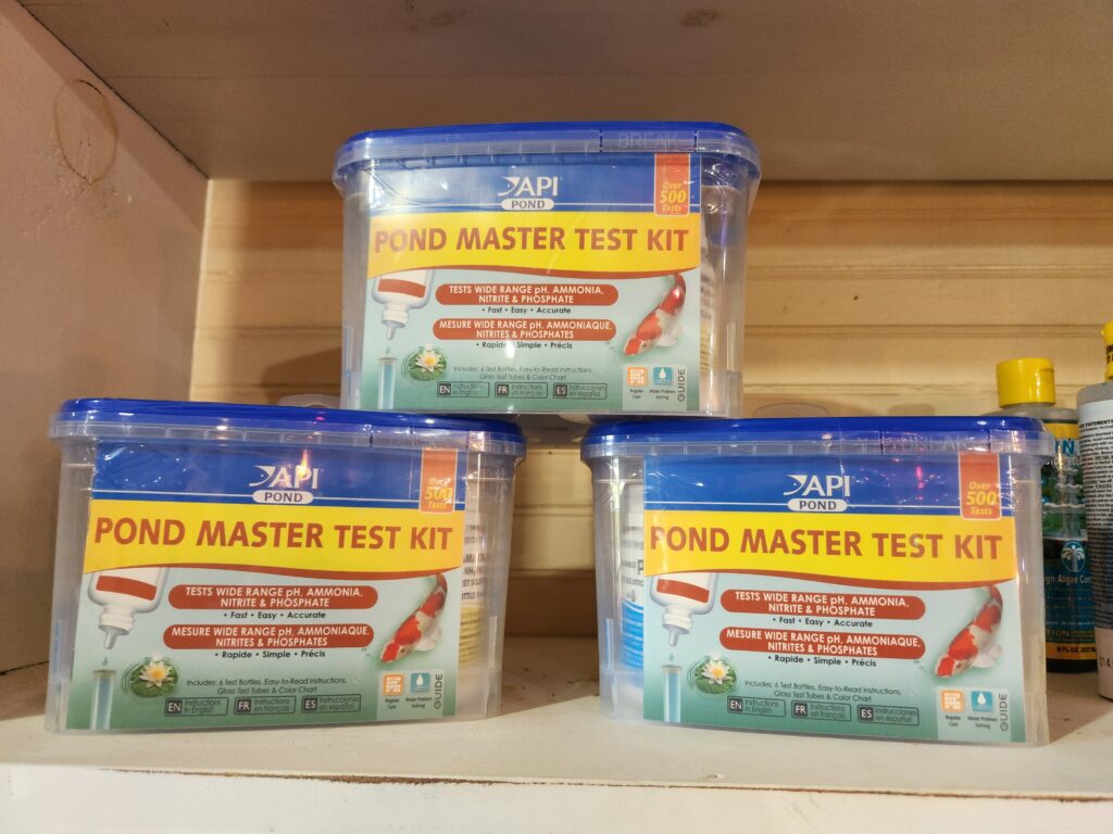 Three containers of pond master test kit on a shelf.